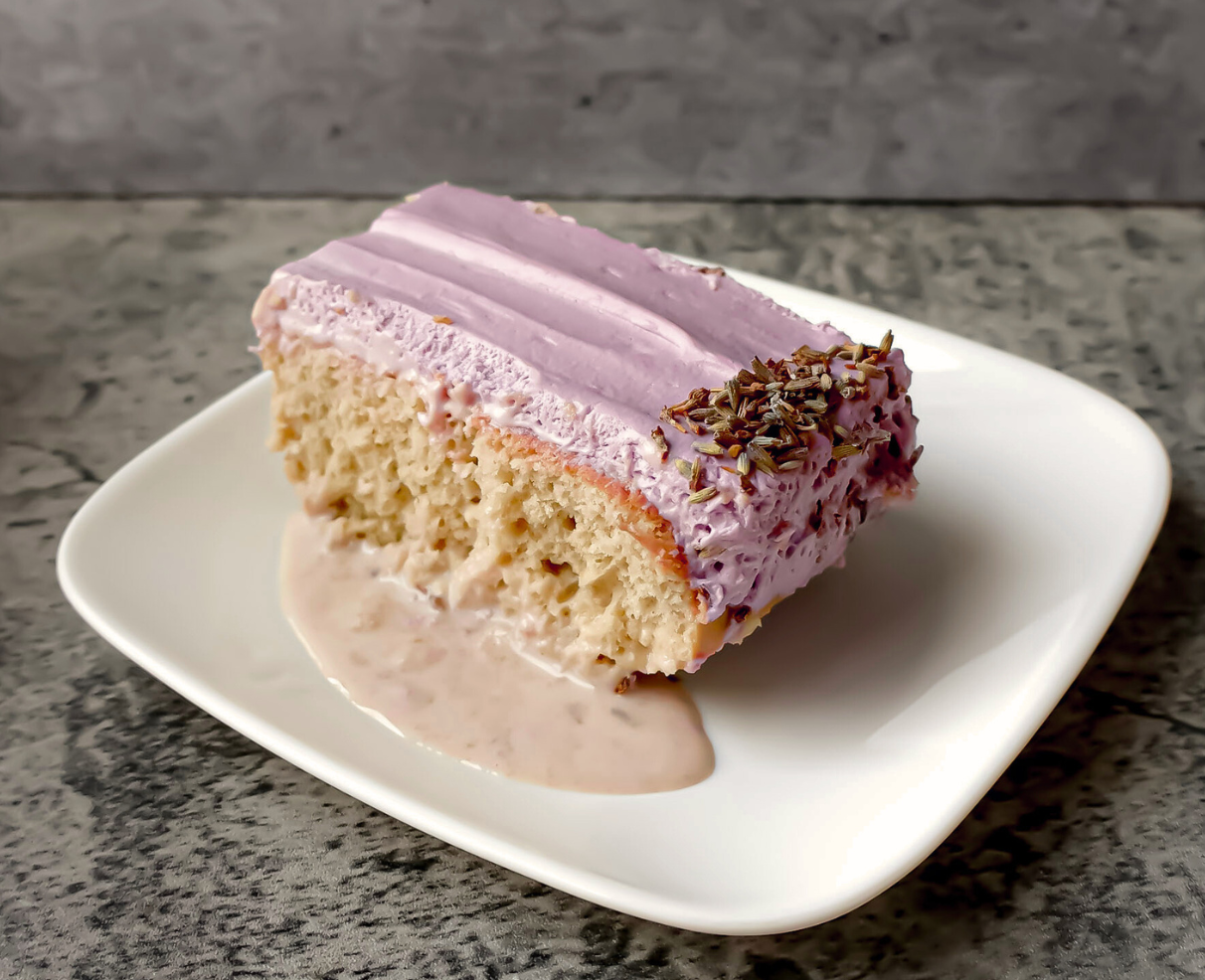 A slice of Moist Earl Grey lavender tres leches cake with creamy lavender whipped topping, inspired by London Fog tea flavors