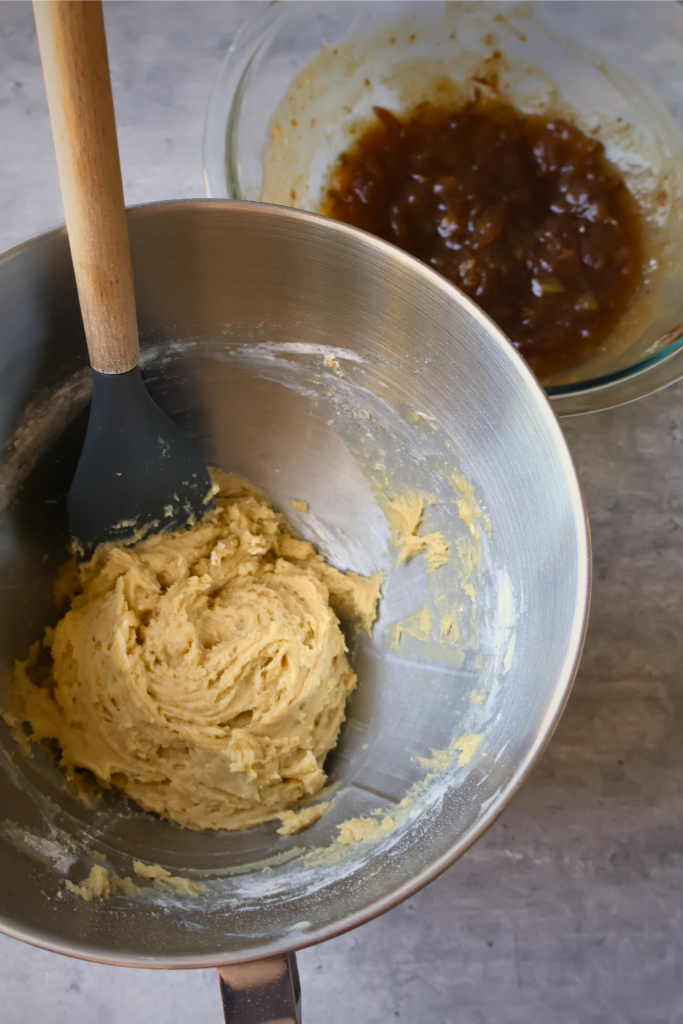 Mixing bowl with sticky toffee pudding batter beside a bowl of homemade date mixture during the baking process.