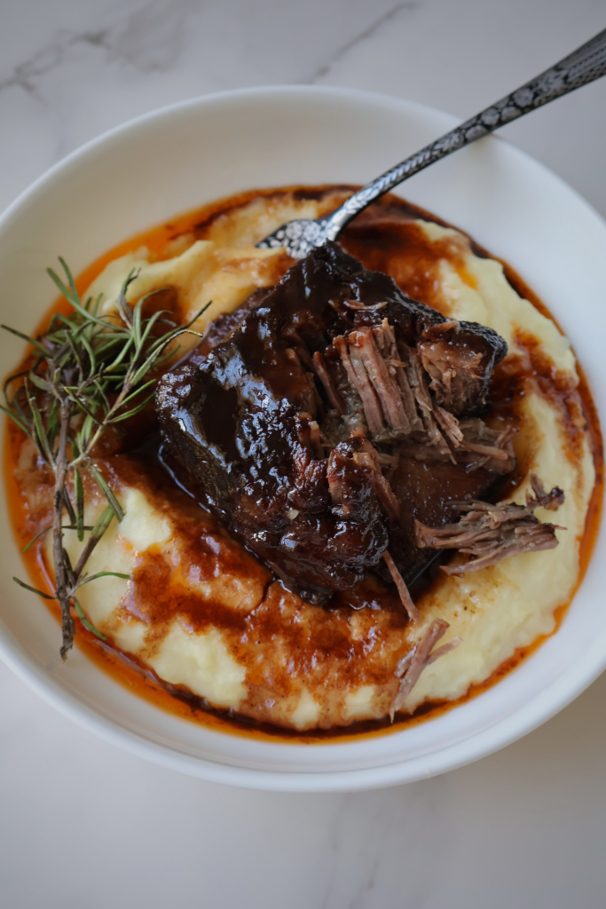 Fork-tender braised beef short ribs served over creamy mashed potatoes with rich pan sauce and fresh rosemary.