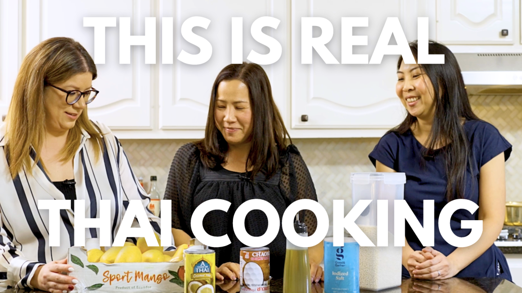 Three women cooking together in a bright kitchen during The Auntie Kitchen, smiling and preparing Thai dishes