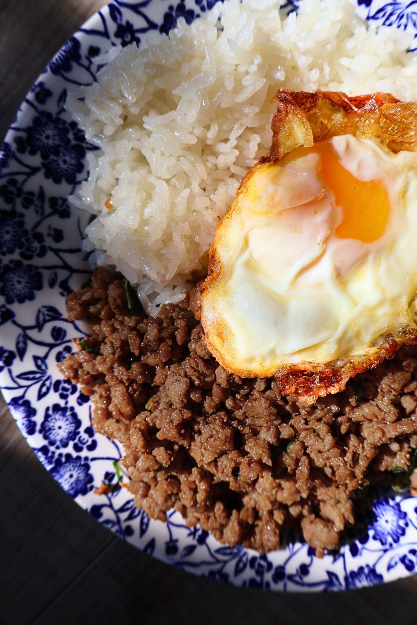 Close-up of Thai pad kra pao with jasmine rice and crispy fried egg with soft yolk