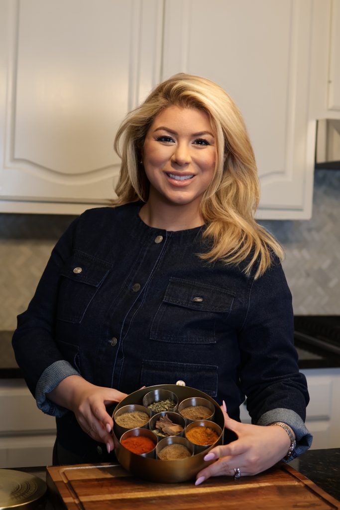 Emilia Kim holding a masala dabba in the kitchen
