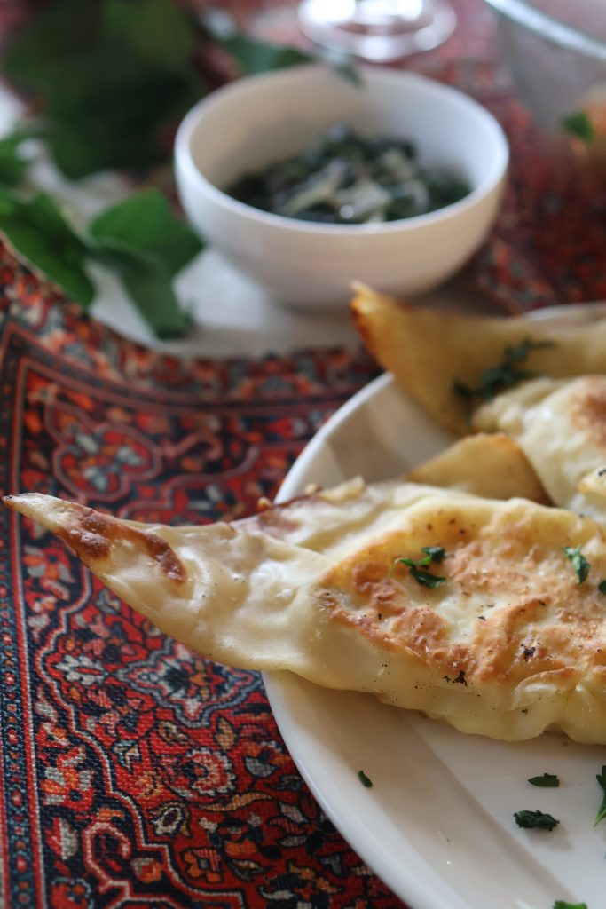 Traditional Afghan bolani stuffed flatbread served with a creamy yogurt dipping sauce and fresh herbs.