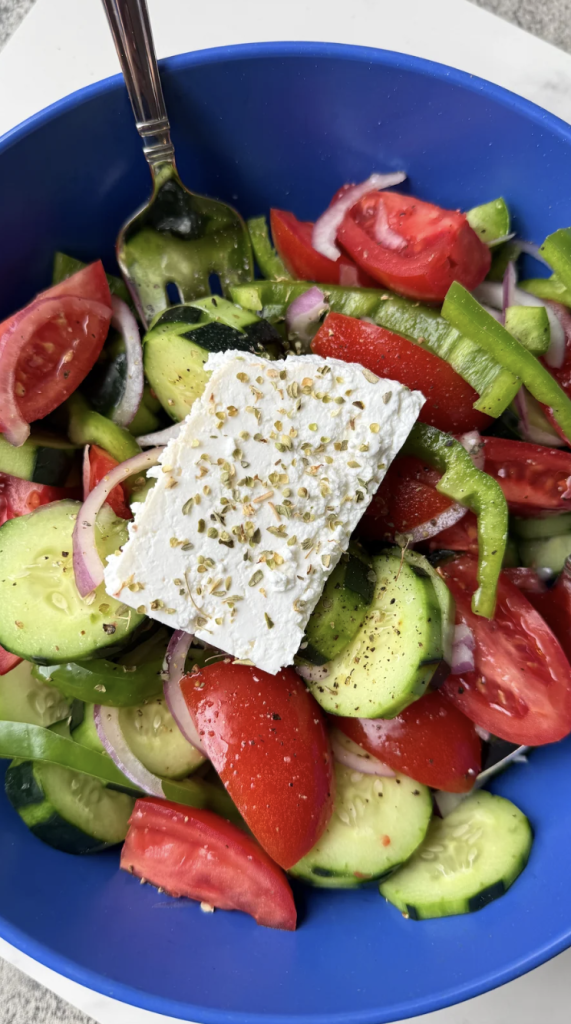 Horiatiki, the original Greek salad with tomato, cucumber, red onion, olives, and a slab of feta on top, no lettuce