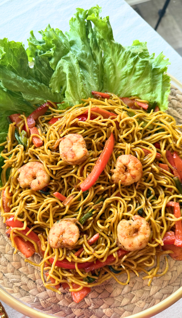 Mine Sao, a traditional Malagasy stir-fried noodle dish with shrimp and vegetables, served on a platter with fresh lettuce.