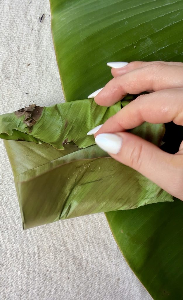 Koba, a traditional Malagasy dessert made from bananas, peanuts, and rice flour, wrapped and steamed in banana leaves.