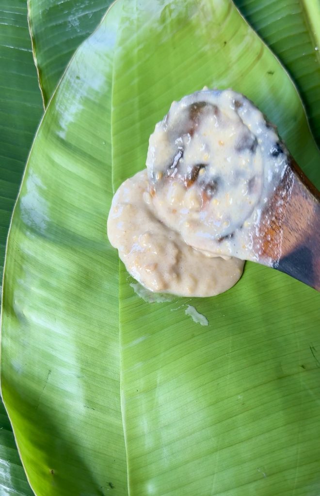 Slice of traditional Malagasy koba showing its dense texture, made with bananas, peanuts, and rice flour, served on a banana leaf.