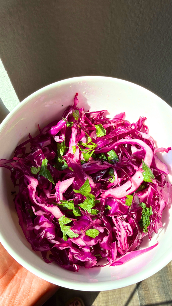 Traditional Turkish red cabbage salad with fresh parsley, served in a white bowl.