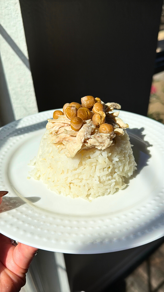 Turkish chicken and rice pilaf topped with chickpeas, served on a white plate.