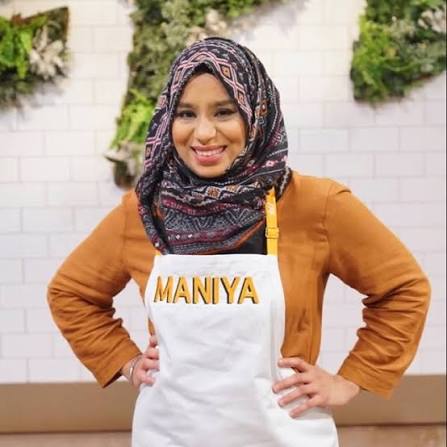 Portrait of Fatima Maniya wearing a patterned hijab and apron, known for sharing South Asian recipes and culinary storytelling.