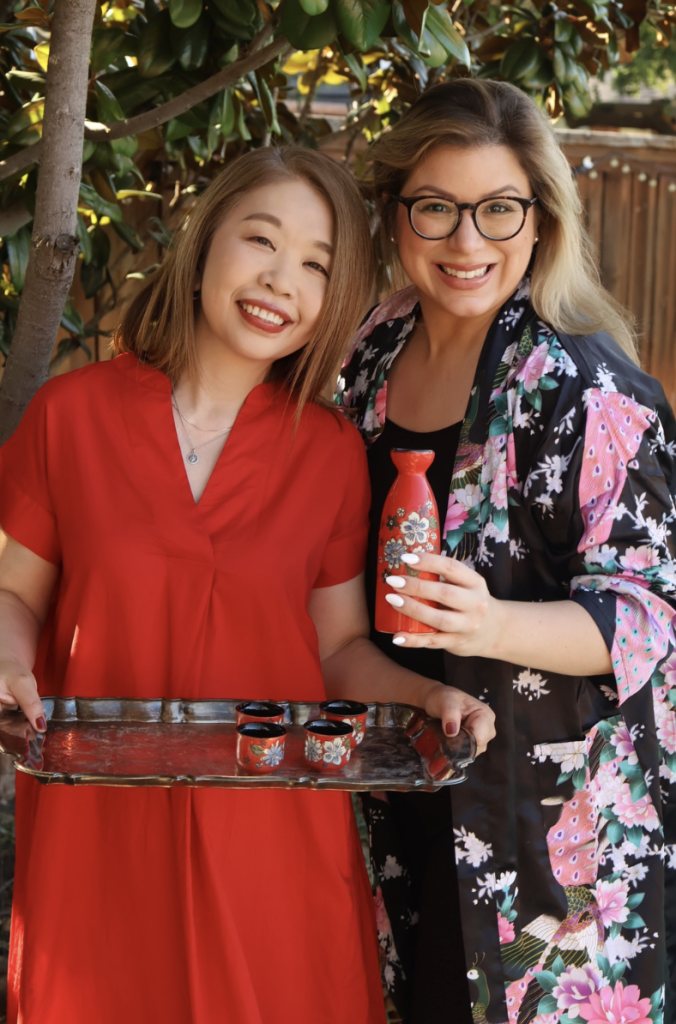 Emilia Kim and a Japanese friend wearing traditional clothing while sharing Japanese food during the Hosting the World Japan experience.