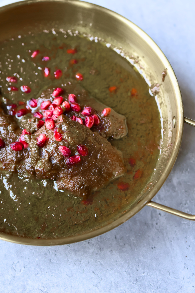 Traditional Persian fesenjan chicken stew made with ground walnuts and pomegranate molasses, garnished with pomegranate seeds.