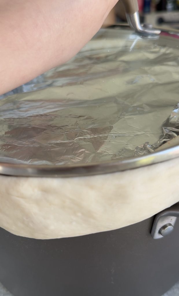 A pot of Bangladeshi kacchi biryani is sealed with a ring of dough and covered before slow cooking using the traditional dum method.