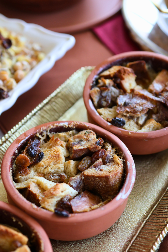 Traditional Egyptian Om Ali baked bread pudding served in individual clay ramekins with a golden, toasted top.