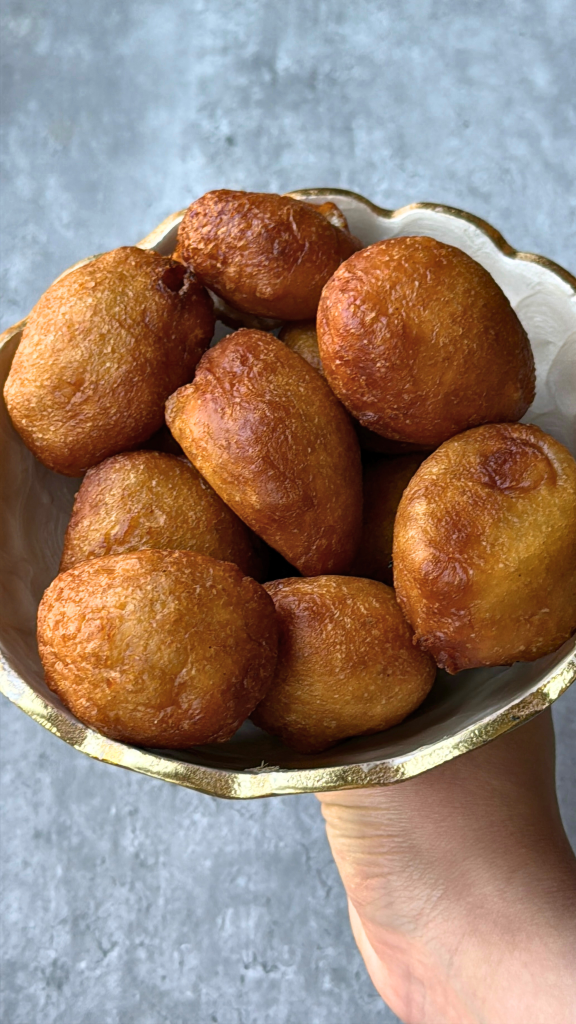 Freshly fried Nigerian puff puff served in a decorative bowl, featuring golden-brown, fluffy sweet dough balls.
