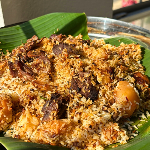 Authentic Bangladeshi kacchi biryani served on a banana leaf, featuring fragrant rice, tender lamb, potatoes, and aromatic spices.
