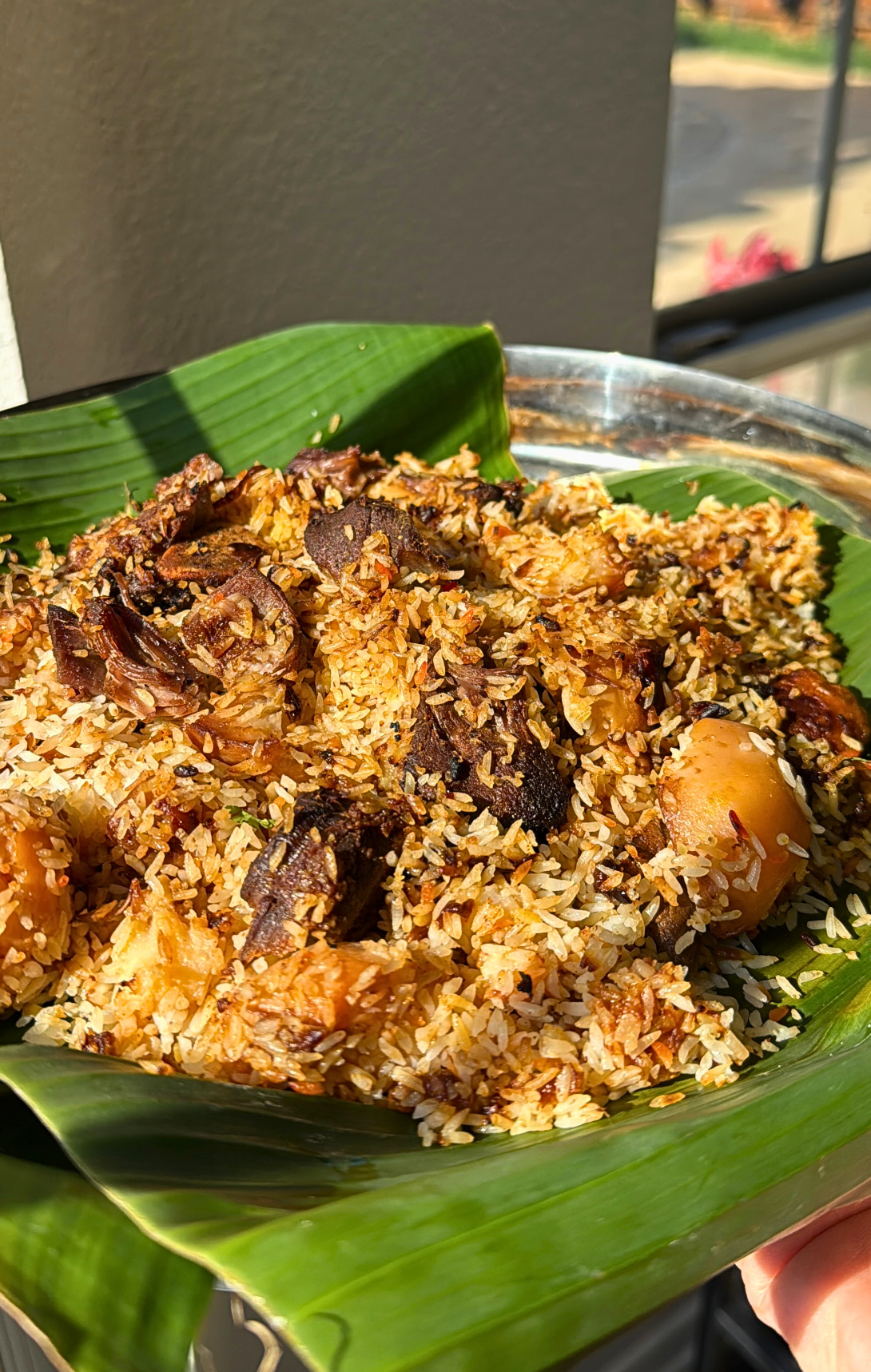 Authentic Bangladeshi kacchi biryani served on a banana leaf, featuring fragrant rice, tender lamb, potatoes, and aromatic spices.